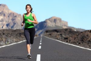 Runner woman running on mountain road in beautiful nature. Asian female sport fitness model jogging training for marathon during outdoor workout.